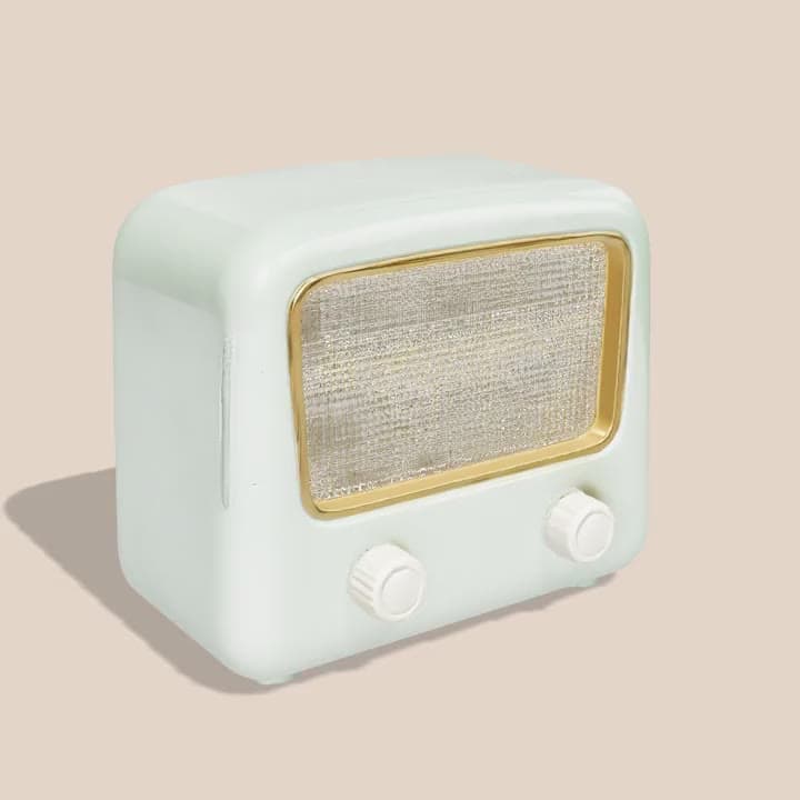 A 3D model of a mint green valve radio with a gold grille and cream knobs, turning on a stand