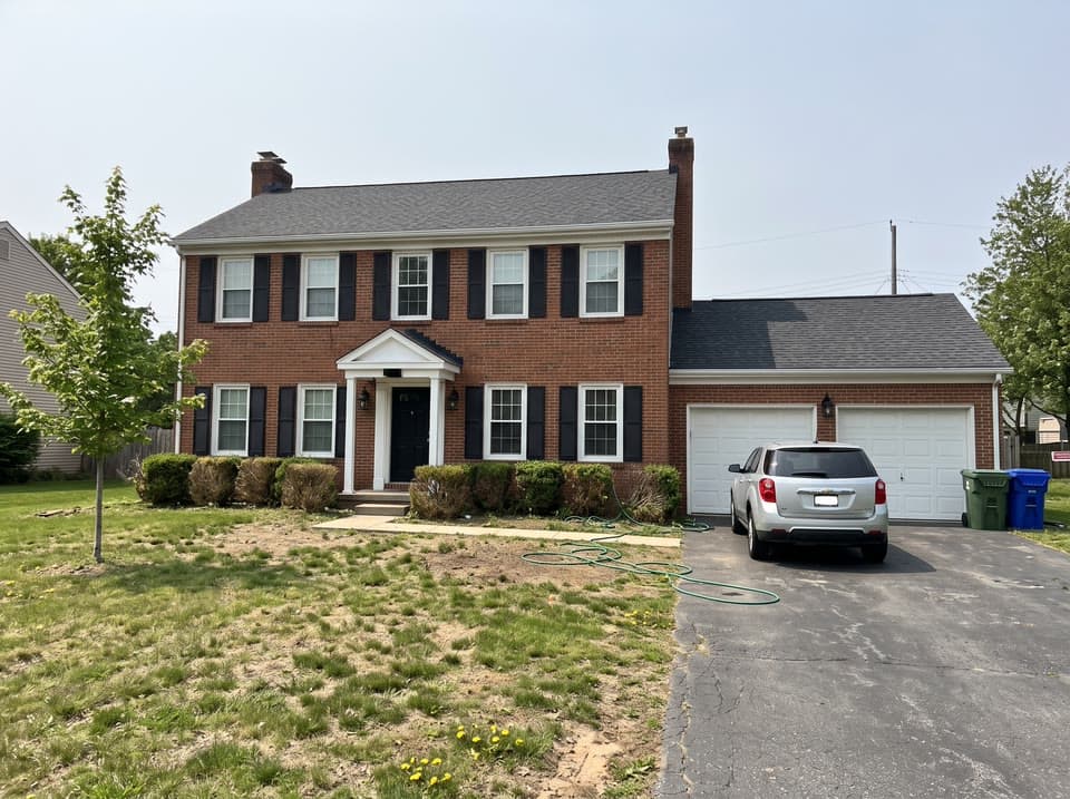 The photo a brick colonial at blue hour, driveway cleared started from